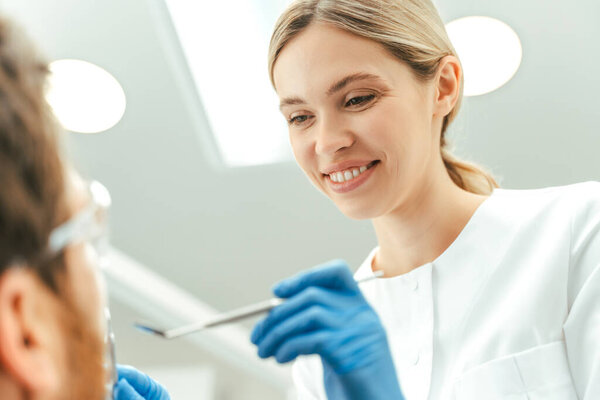 Dentist examining patient in modern dental clinic. Teeth treatment, health care, oral hygiene concept 