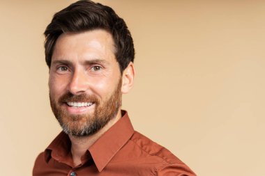 Yakışıklı, gülümseyen orta yaşlı bir adamın portresi, arka planda izole edilmiş kameraya bakan yakışıklı bir iş adamı, fotokopi odası. Berber dükkanından sonra mutlu sakallı hippi.