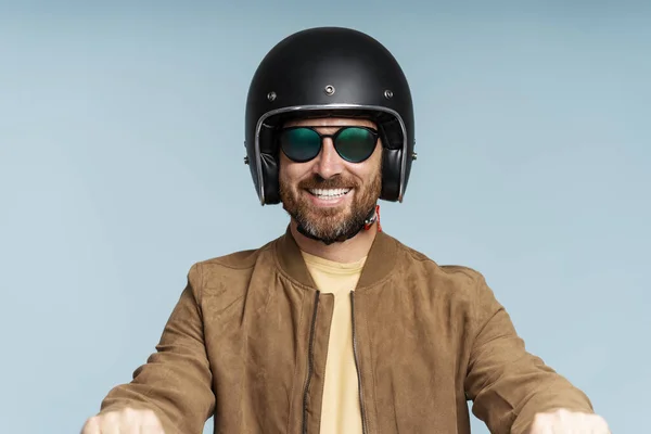 ハンサムな笑顔のひげ付き男性の肖像画 ヘルメットを着用したバイカー スタイリッシュな眼鏡 ブルーの背景に隔離されたレザージャケットライディングバイク 交通コンセプト — ストック写真
