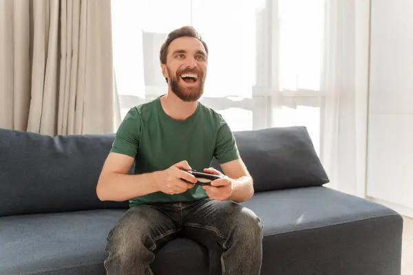 Портрет Возбужденного Привлекательного Бородатого Мужчины Геймера Играющего Видеоигру Держащего Джойстик — стоковое фото