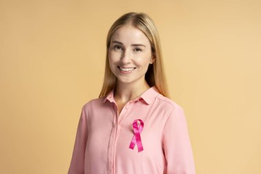 Arka planda pembe kurdeleli gülümseyen kadın. Sağlık hizmetleri. Göğüs kanseri farkındalığı ayı