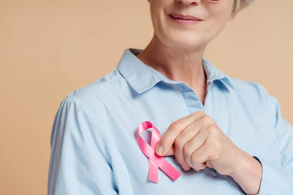stock image Senior woman holding pink ribbon isolated on background. Breast cancer awareness month concept