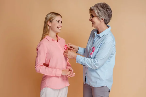 Lächelnde Frauen Befestigen Rosafarbene Schleifen Die Sich Isoliert Anschauen Konzept — Stockfoto
