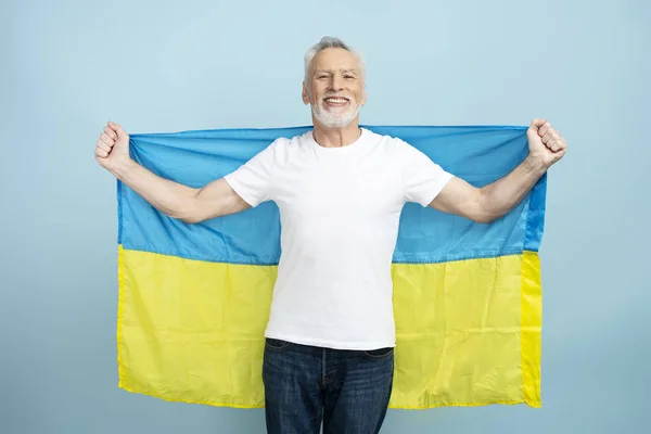 Mavi Arka Planda Ukrayna Bayrağı Taşıyan Gülümseyen Olgun Bir Adam — Stok fotoğraf