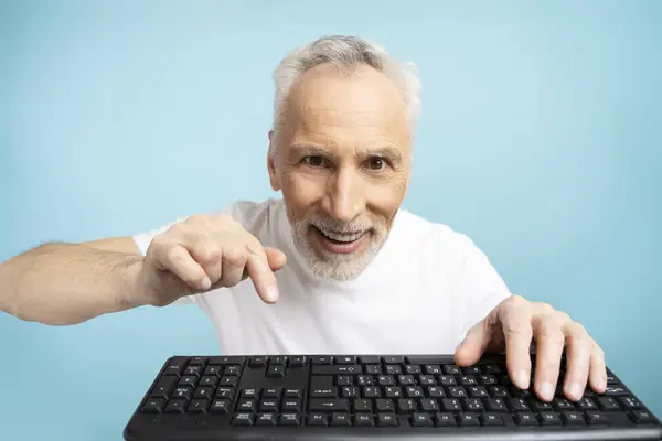 Klavyede Yazan Gülümseyen Yaşlı Bir Adamın Portresi Mavi Arka Planda — Stok fotoğraf