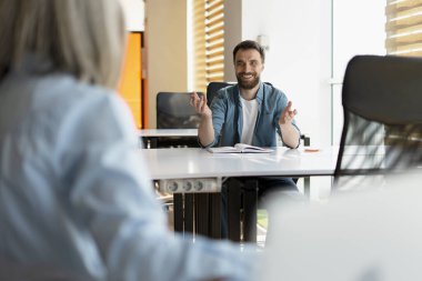 Kendinden emin gülümseyen iş adamları, iş arkadaşları konuşuyor, girişimi planlıyor, fikirleri paylaşıyor, tartışıyorlar, modern ofiste birlikte çalışıyorlar. Toplantı, takım çalışması, başarılı iş 