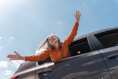 Arabanın içinde el ele tutuşan yaşlı gri saçlı mutlu bir kadın. Özgürlük, yolculuk, tatil