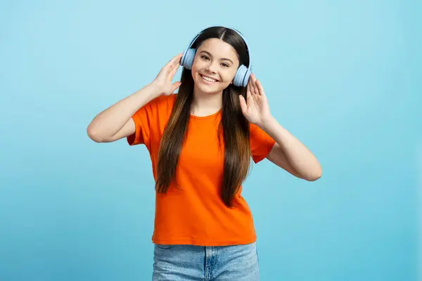 Selamat Tersenyum Gadis Remaja Mengenakan Kemeja Oranye Mendengarkan Musik Headphone — Stok Foto