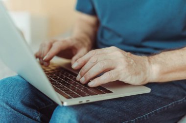 Forumda yazan metin yazarı, dizüstü bilgisayar kullanan yazar, bilgisayarda çalışan yönetici, evde çalışan, yakın plan, seçici odaklanma. Erkek öğrenci stili. Uzak görev kavramı