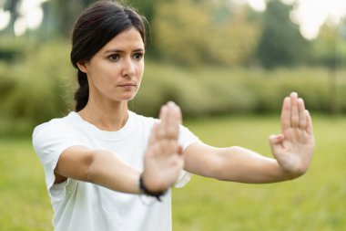 Ciddi kadın eğitiminin portresi, parkta Wushu çalışması. Sağlıklı yaşam tarzı, kung fu, dövüş sanatları konsepti
