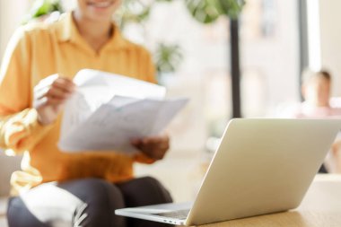 Güzel gülümseyen Afro-Amerikan iş kadını, elinde bilgisayarla evde çalışan serbest çalışan bir iş kadını. Başarılı bir iş. 