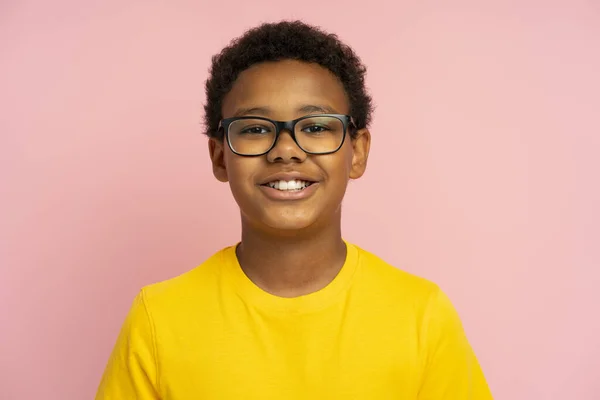 ピンクの背景に隔離されたスタイリッシュな眼鏡を身に着けている笑顔の学校の少年 教育コンセプト — ストック写真