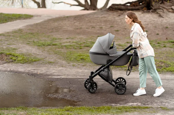 Niezadowolona Młoda Matka Spacery Duża Kałuża Przeszkód Wodnych Pchania Wózek — Zdjęcie stockowe