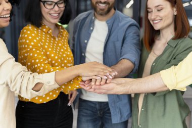 Modern ofis binasında el ele tutuşan bir iş arkadaşı ekibi. - İnsanlar. Başarı. Motivasyon. Gol başarısı. İş için. Takım oluşturma. Adam alımı. Yönetimden. İnsan kaynakları.