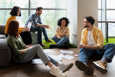 Çeşitli üniversite mezunu öğrenciler kütüphane kampüsünde birlikte yeni bir proje üzerinde çalışıyorlar. Takım arkadaşlarıyla iş ortaklarından oluşan başarılı bir ekip takım oluşturma eğitimi sırasında planlarını tartışıyor.