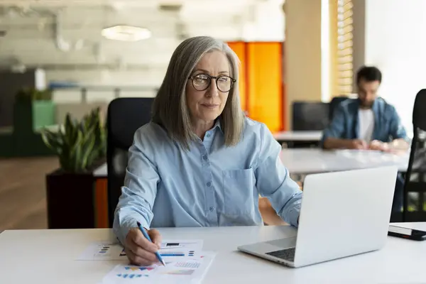 Seriöse Reife Geschäftsfrau Mit Laptop Computer Notizen Machen Arbeitsprojekt Modernen — Stockfoto