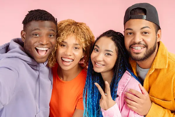 stock image Group of attractive smiling friends taking selfie, hugging together isolated on pink background 