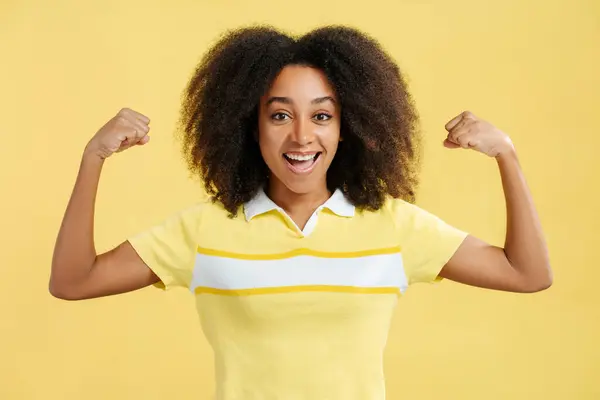 Positieve Opgewonden Afro Amerikaanse Vrouw Met Krullend Haar Toont Biceps — Stockfoto