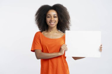 Beyaz arka planda izole edilmiş, turuncu tişört ya da afiş taşıyan güzel, gülümseyen Afro-Amerikan kadınlarının portresi. Reklam kavramı