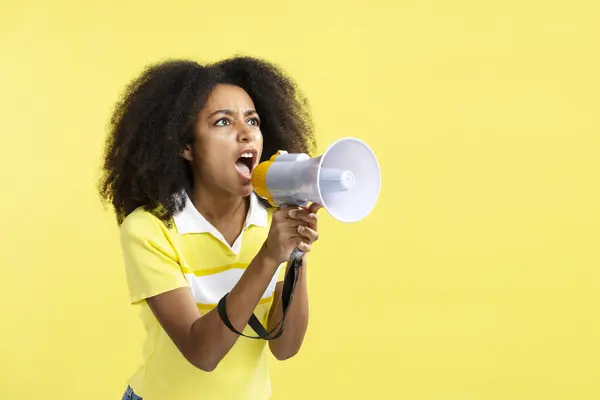 年轻而愤怒的非裔美国女人拿着扩音器尖叫着赞美被黄色背景隔离的销售 黑色星期五概念 — 图库照片