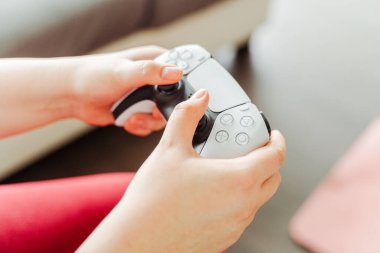 Yakın plan, elinde joystickle oynayan kadın oyuncu, evinde, evinde, seçici bir odak noktasında video oyunu oynuyor. Teknoloji kavramı, eğlence
