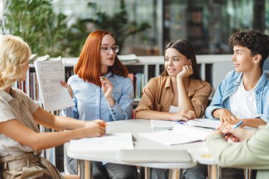 Öğretmen ya da profesyonel öğretmen asistanlığı, bir şeyleri açıklamak, dil öğrenmek, ders almak, modern sınıfta zeki gençlerle çalışmak. Eğitim, okula dönüş konsepti. 