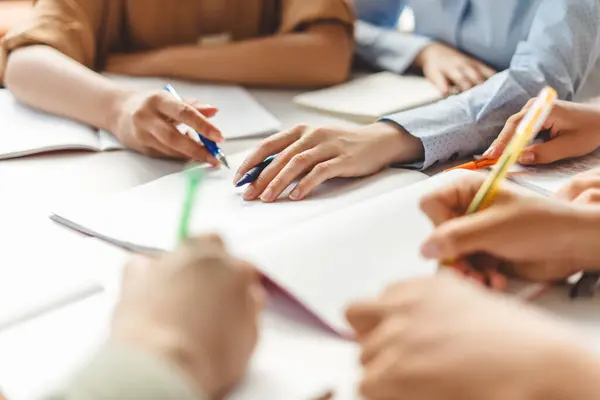 stock image Closeup of business people hands writing, taking notes working together in office. Colleagues sharing ideas, planning startup project indoors. Teamwork concept 