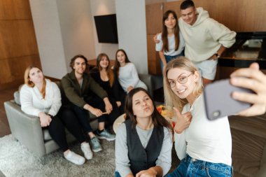 İş arkadaşları evde toplanırken akıllı telefonlardan selfie çekiyorlar. Sarışın bir kadın cep telefonu tutuyor, arkadaşlarıyla buluşuyor, bir parti sırasında masanın etrafında. 