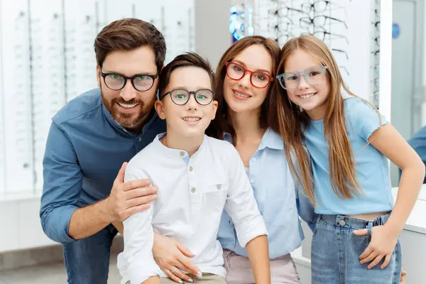 Uśmiechnięci Rodzice Dwójka Dzieci Wybierających Okulary Podczas Pozowania Sklepie Optycznym — Zdjęcie stockowe