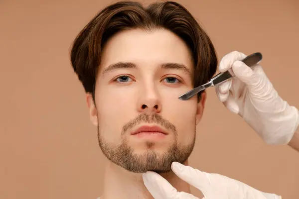 Young Man Surgeon Hands Scalpel Male Face Cosmetic Operation Isolated — Stock Photo, Image