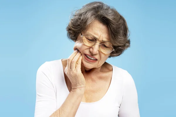 Печально Пожилая Женщина Обнимающей Щеке Зубной Болью Синем Фоне Боль — стоковое фото