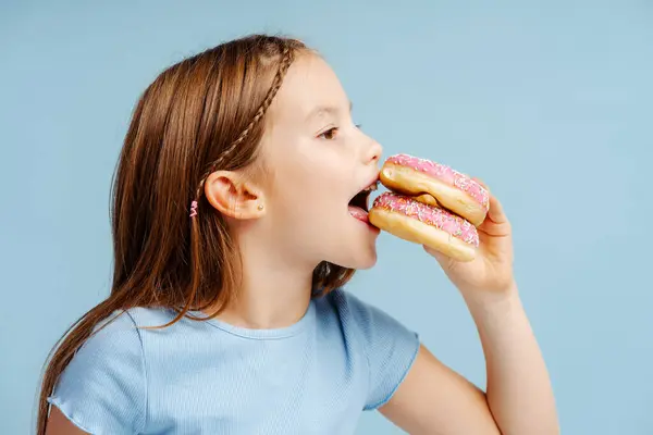 Πορτρέτο Του Χαρούμενος Κοριτσάκι Τρώει Ροζ Ντόνατ Όρεξη Ενώ Στέκεται — Φωτογραφία Αρχείου