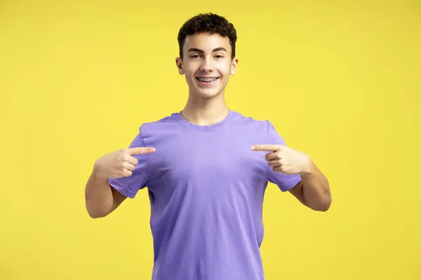 Sonriente Adolescente Con Camiseta Púrpura Casual Apuntándose Mismo Mirando Cámara —  Fotos de Stock