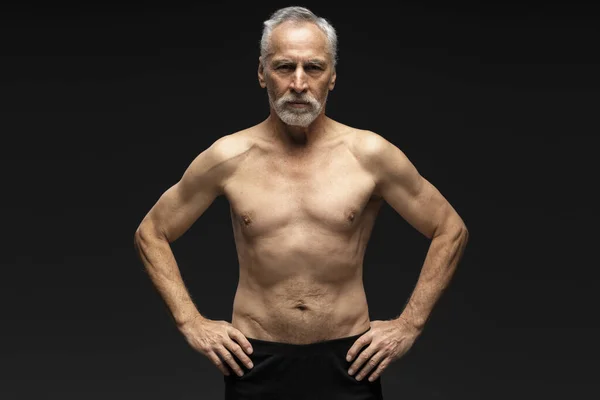 严肃而自信的老年男子的画像 白发苍苍 没穿上衣 凝视着站在黑色背景上的相机 健康生活方式概念 — 图库照片