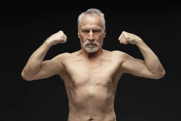 高个子白发大胡子男子的画像 光秃秃的躯干显示出二头肌 肌肉发达的身体看着被黑色背景隔离的相机 健康生活方式概念 — 图库照片