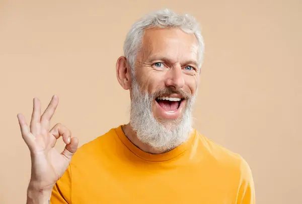 Pohledný Usmívající Let Starý Muž Stylovými Šedými Vlasy Neformální Oranžové — Stock fotografie