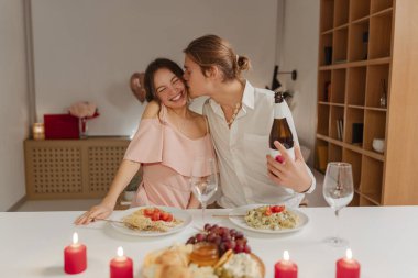 Gülümseyen mutlu bir adam güzel bir kadını öpüyor. Mutlu bir çift portresi, Sevgililer Günü 'nü kutlayan bir aile. Romantik akşam yemeği konsepti, aşk