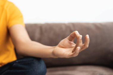 Modern Afrikalı Amerikalı bir adamın portresi, şık kıyafetler giyen hippi nilüfer pozisyonunda oturuyor, el hareketleriyle işaret ediyor, yakın çekime odaklanıyor. Uyum kavramı