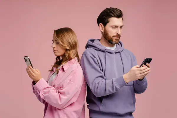 Några Allvarliga Vänner Som Håller Mobiltelefoner Kommunikation Online Isolerad Rosa — Stockfoto