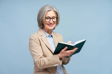 Gülümseyen yaşlı kadın, elinde not defteri tutan yazar, not alan, mavi arka planda izole edilmiş yeni bir kitap planlayan. Kendine güvenen yönetici beyin fırtınası yapıyor, çalışıyor. Başarılı iş konsepti