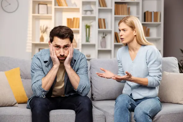 stock image Assistance for troubled families concept. A furious wife yelling at her spouse, conflict erupting on the living room couch