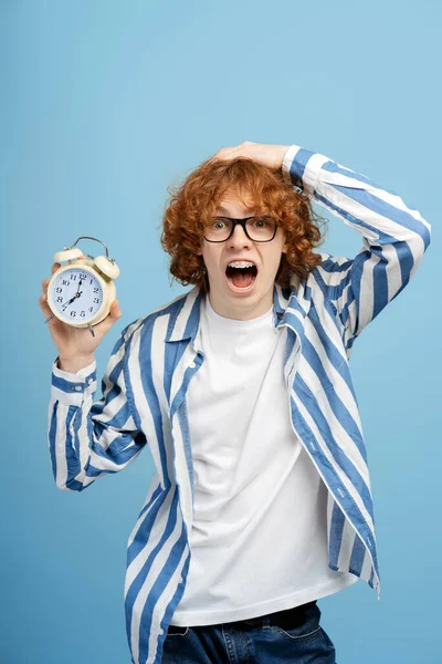Shocked Teenager Holding Alarm Clock Screaming Because Oversleep Isolated Blue — Stock Photo, Image