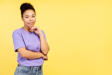 Gülümseyen, neşeli Afro-Amerikan kadın portresi, manken, günlük kıyafetler giyen, kameraya bakan, sarı arka plan fotokopi alanında tek başına duran. Reklam kavramı, alışveriş.