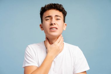 Hasta kıvırcık çocuğun boğazı ağrıyor, ağrısı güçlü, tıbbi tedaviye ihtiyacı var. Sağlık hizmeti kavramı 