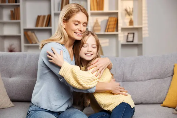 Familia Feliz Casa Sonriente Madre Abrazando Pequeña Hija Ambos Sentados —  Fotos de Stock