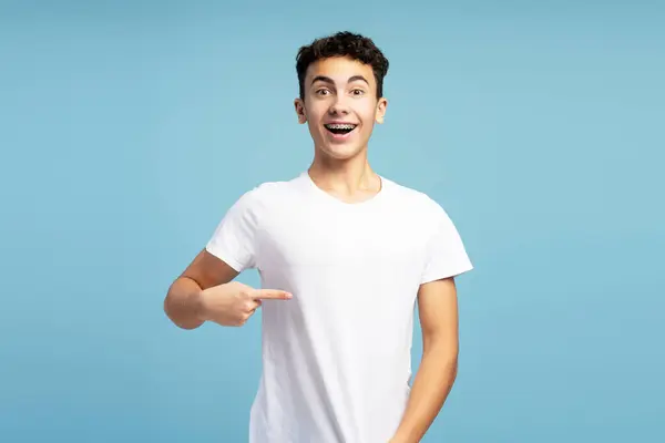 Sonriente Chico Emocionado Vistiendo Camiseta Blanca Señalándola Con Dedo Maqueta —  Fotos de Stock