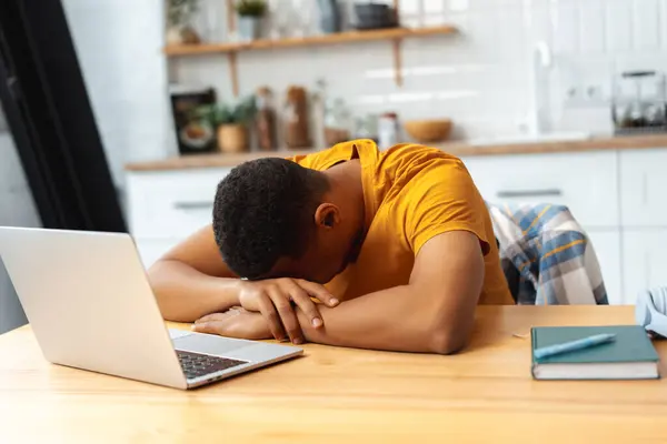 Üzgün Yorgun Afrikalı Amerikalı Genç Adam Dizüstü Bilgisayar Kullanıyor Mutfaktaki — Stok fotoğraf