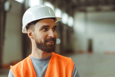 Yakışıklı, sakallı, beyaz adam, profesyonel ustabaşı, mimar, başlık takmış, iş kıyafetleri giymiş, fotokopi odasına bakıyor, içeride dikiliyor. Depo çalışması konsepti