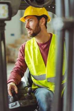 Çekici, gülümseyen adam, operatör, kasklı şoför, forklift, depoda çalışan. Ulaşım ve endüstri kavramı