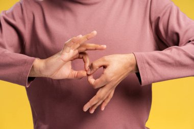 Sarı arka planda izole edilmiş işaret dilinde sözcükler gösteren adama yaklaş. Halk yaşam tarzı konsepti